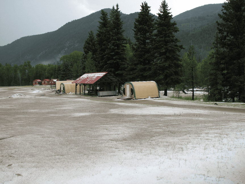 snow covered weatherport cabins at a campground